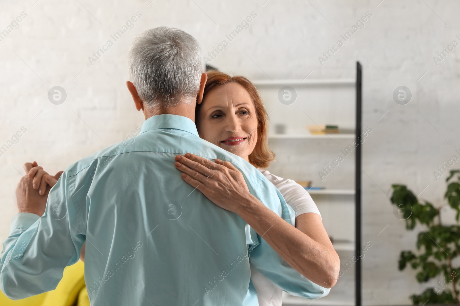 Photo of Happy senior couple dancing together at home