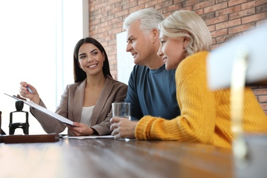 Female notary working with mature couple in office