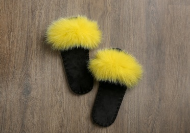 Pair of soft slippers on wooden background, flat lay