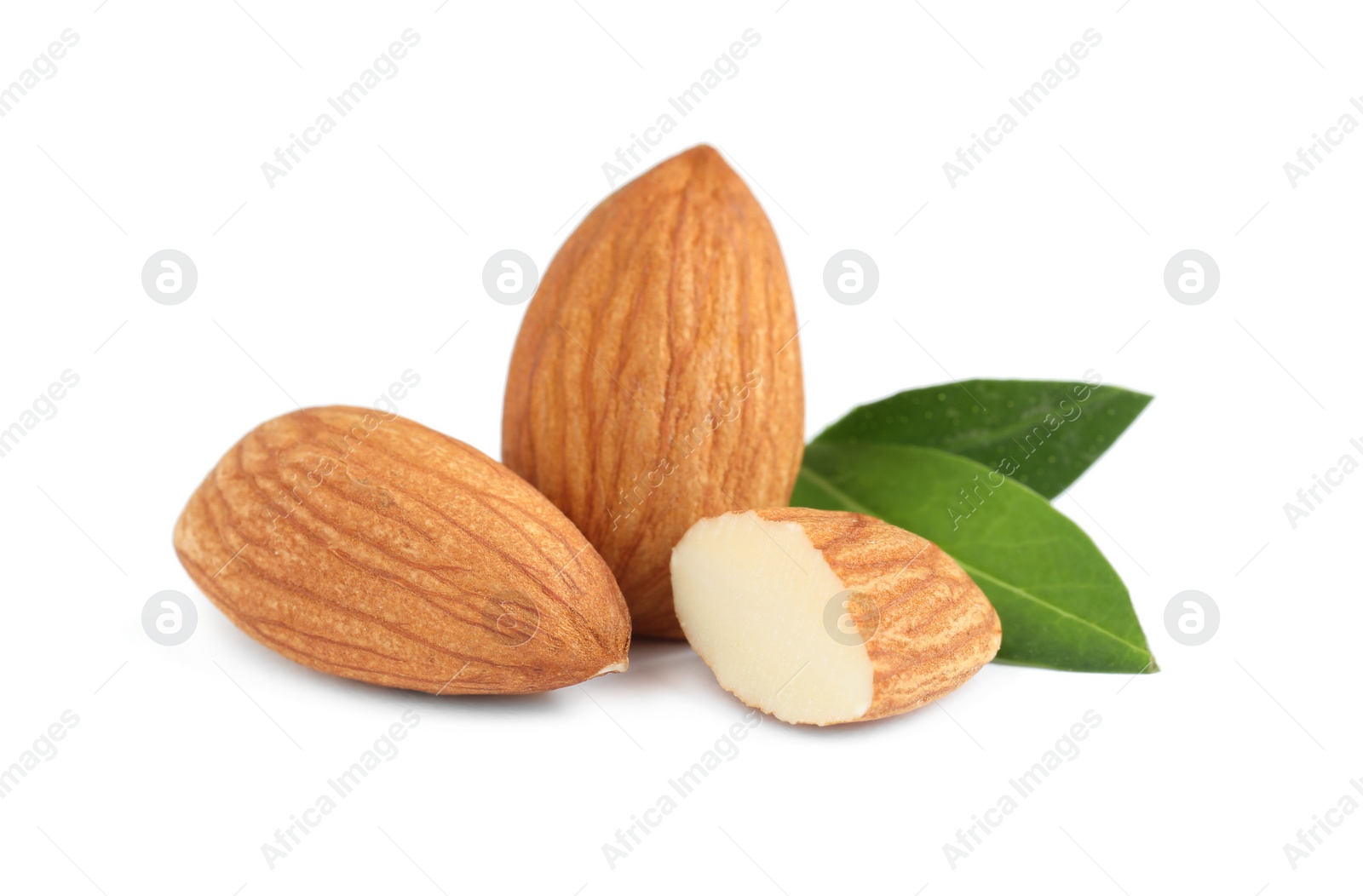 Photo of Organic almond nuts and green leaves on white background. Healthy snack