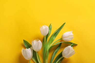 Photo of Many beautiful tulips on yellow background, flat lay. Space for text