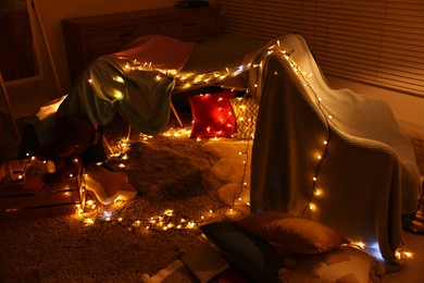 Beautiful play tent decorated with festive lights at home