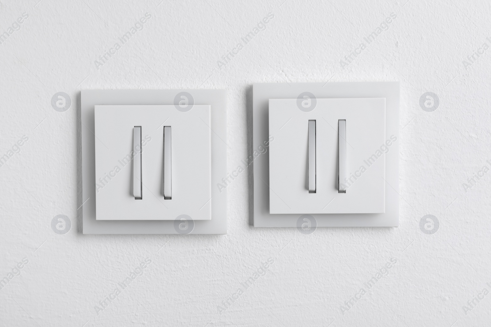 Photo of Modern plastic light switches on white background