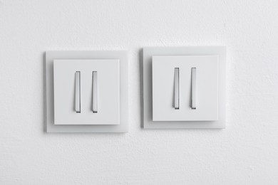 Photo of Modern plastic light switches on white background