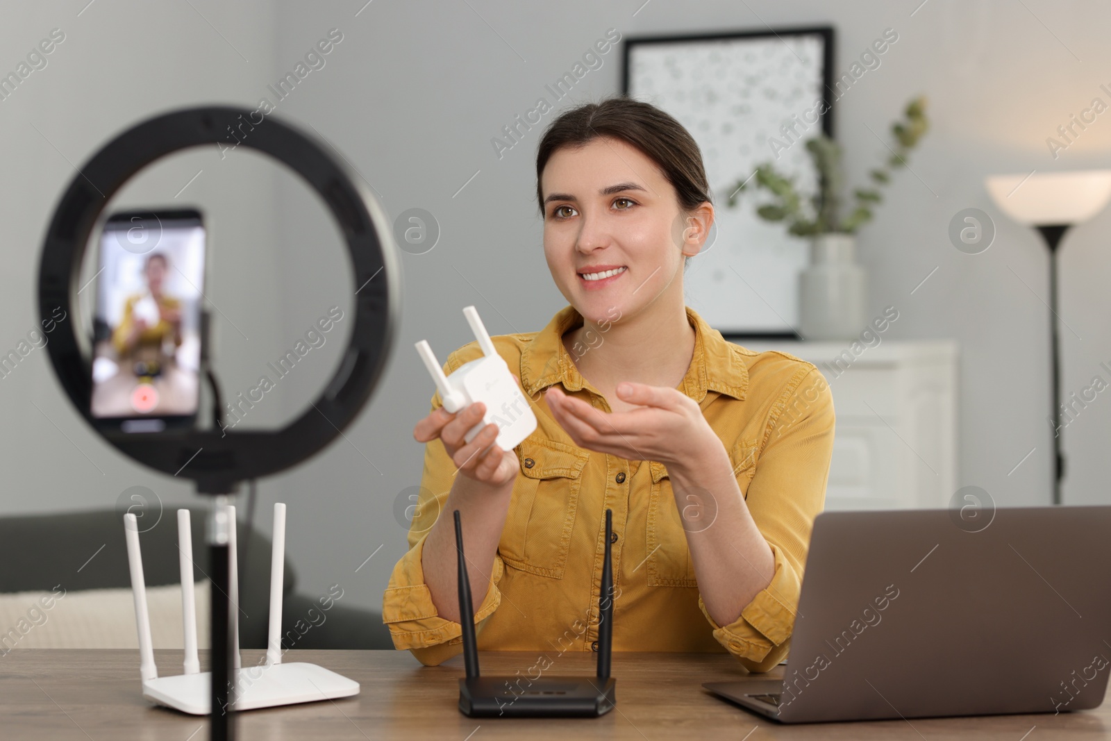 Photo of Smiling technology blogger recording video review about WI-FI devices at home