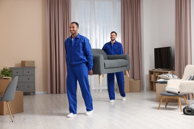 Male movers carrying sofa in new house
