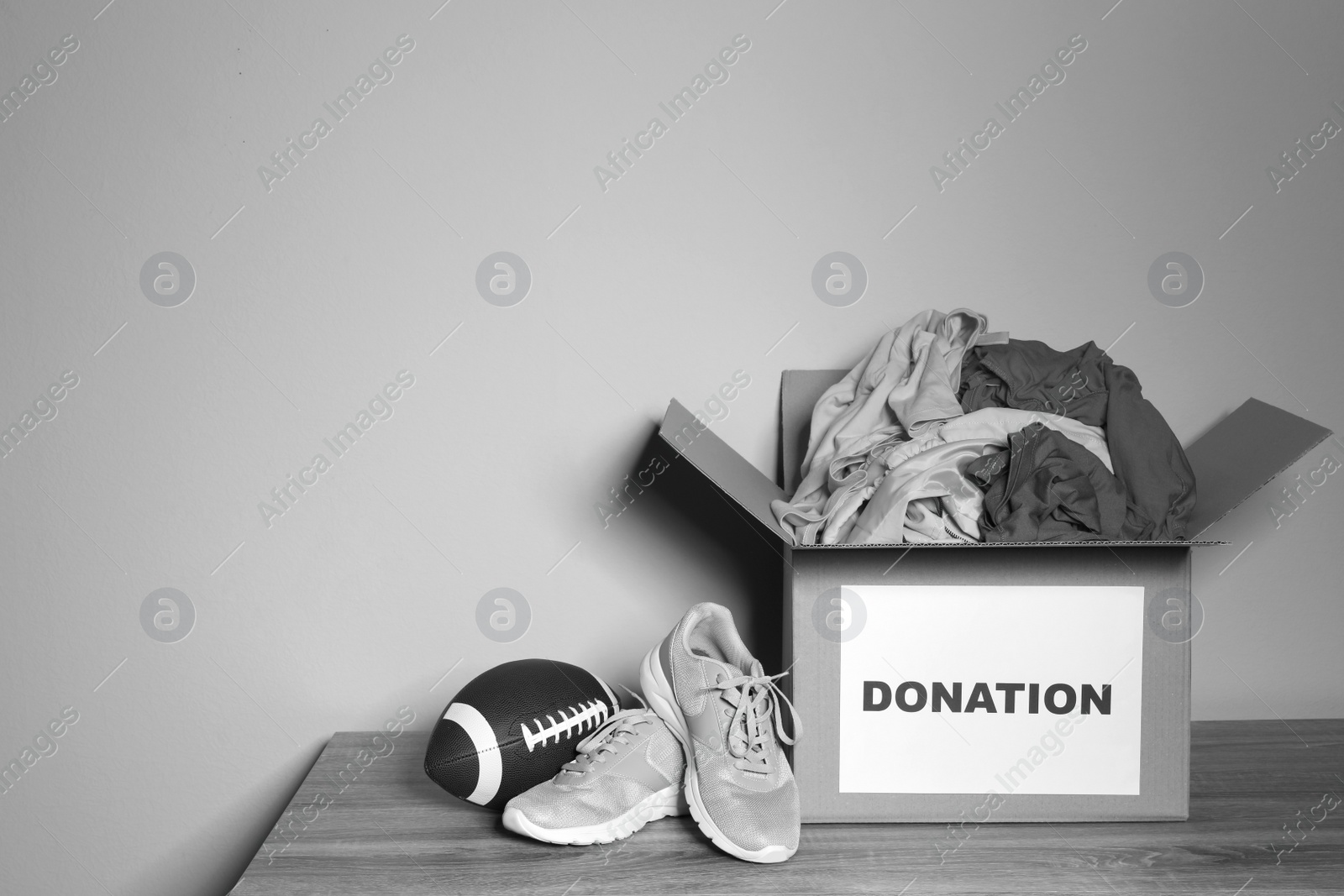 Photo of Donation box on table against grey background with space for text. Black and white effect