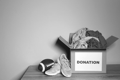 Photo of Donation box on table against grey background with space for text. Black and white effect