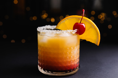 Fresh alcoholic Tequila Sunrise cocktail on black table