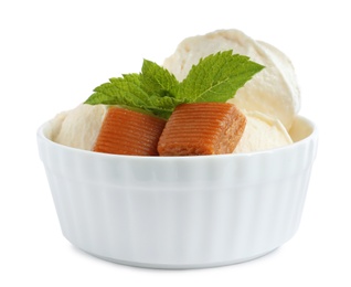 Photo of Bowl of delicious ice cream with caramel candies and mint on white background