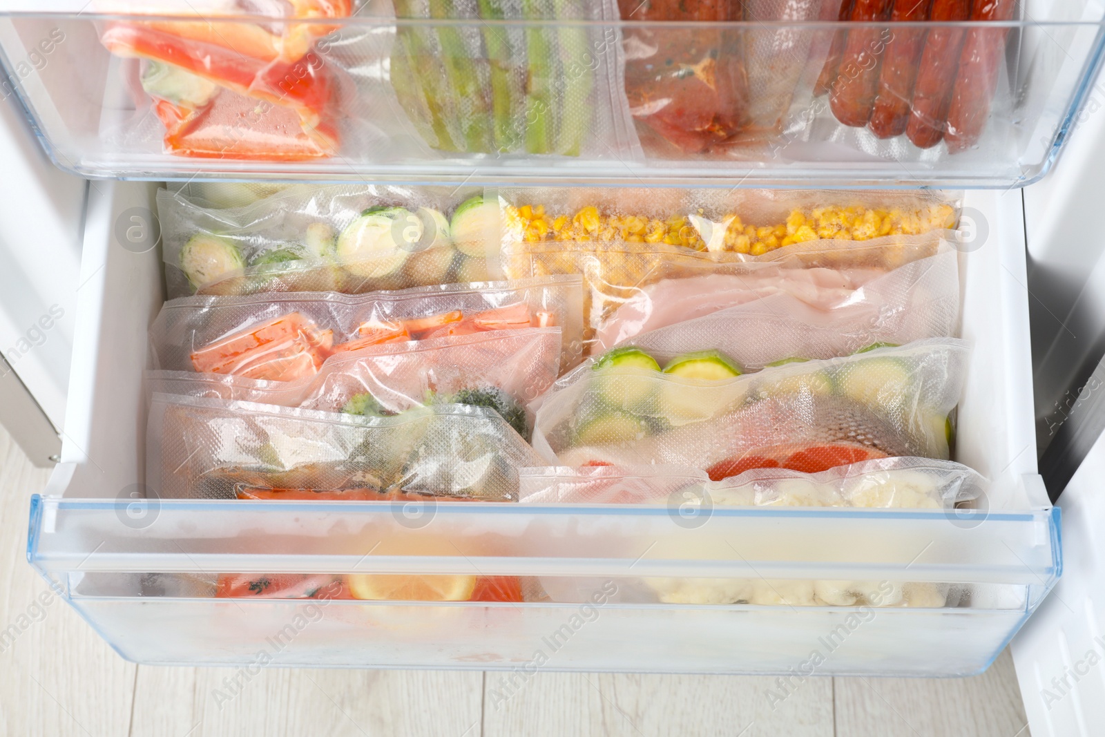 Photo of Vacuum bags with different products in fridge, above view. Food storage