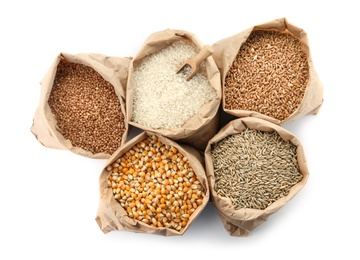 Paper bags with different types of grains and cereals on white background