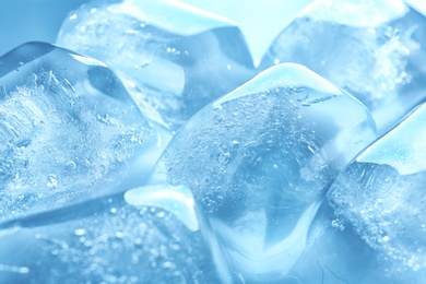 Photo of Transparent ice cubes as background, closeup view