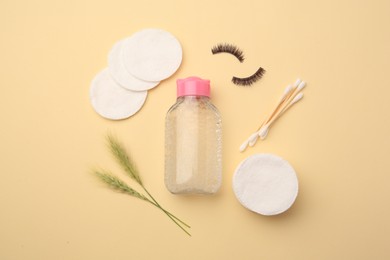 Photo of Flat lay composition with makeup removal tools, spikelets and false eyelashes on yellow background