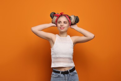 Photo of Beautiful woman with braided double buns on orange background