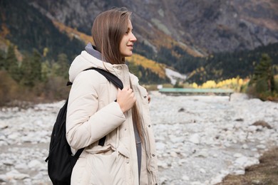 Photo of Woman with backpack in beautiful mountains. Space for text