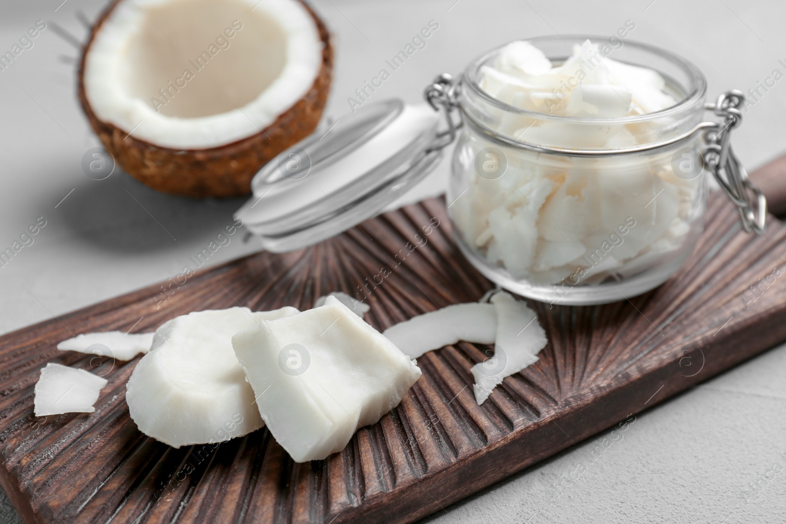 Photo of Fresh coconut flakes in glass jar on light background