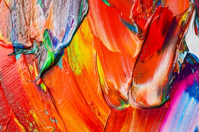 Photo of Strokes of colorful acrylic paints as background, closeup view