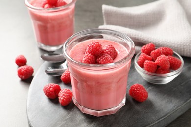 Photo of Delicious raspberry mousse served on grey table