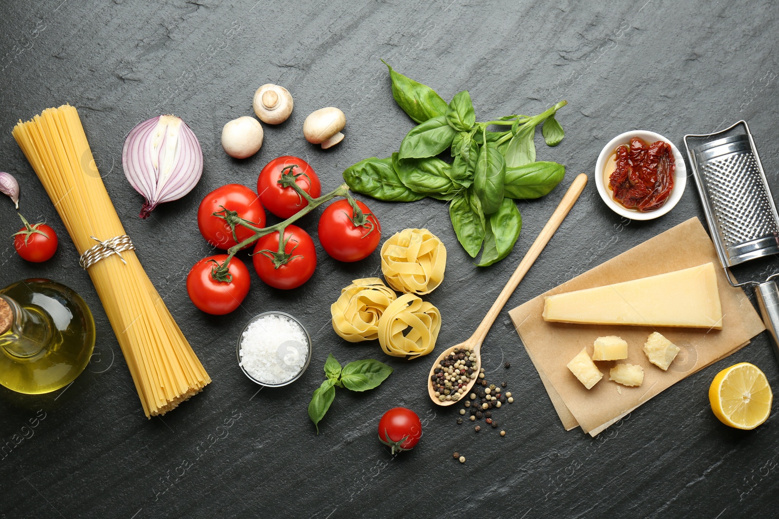 Photo of Different types of pasta, spices, garter and products on dark textured table, flat lay