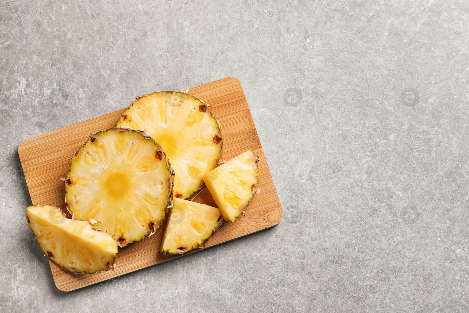 Photo of Slices of fresh pineapple on wooden board