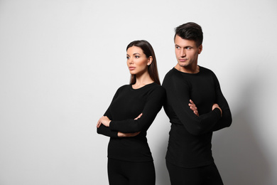 Photo of Couple wearing thermal underwear on light grey background. Space for text