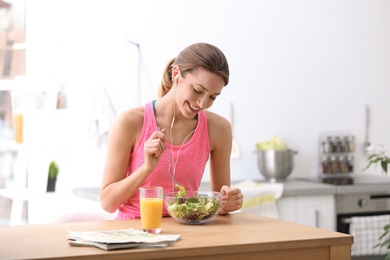 Photo of Young woman in fitness clothes having healthy breakfast at home