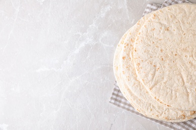 Corn tortillas on light background, top view with space for text. Unleavened bread