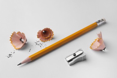 Graphite pencil, shavings and sharpener on white background