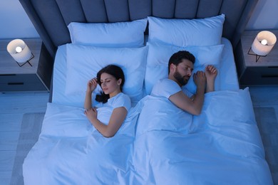 Lovely couple sleeping together in bed at night, top view