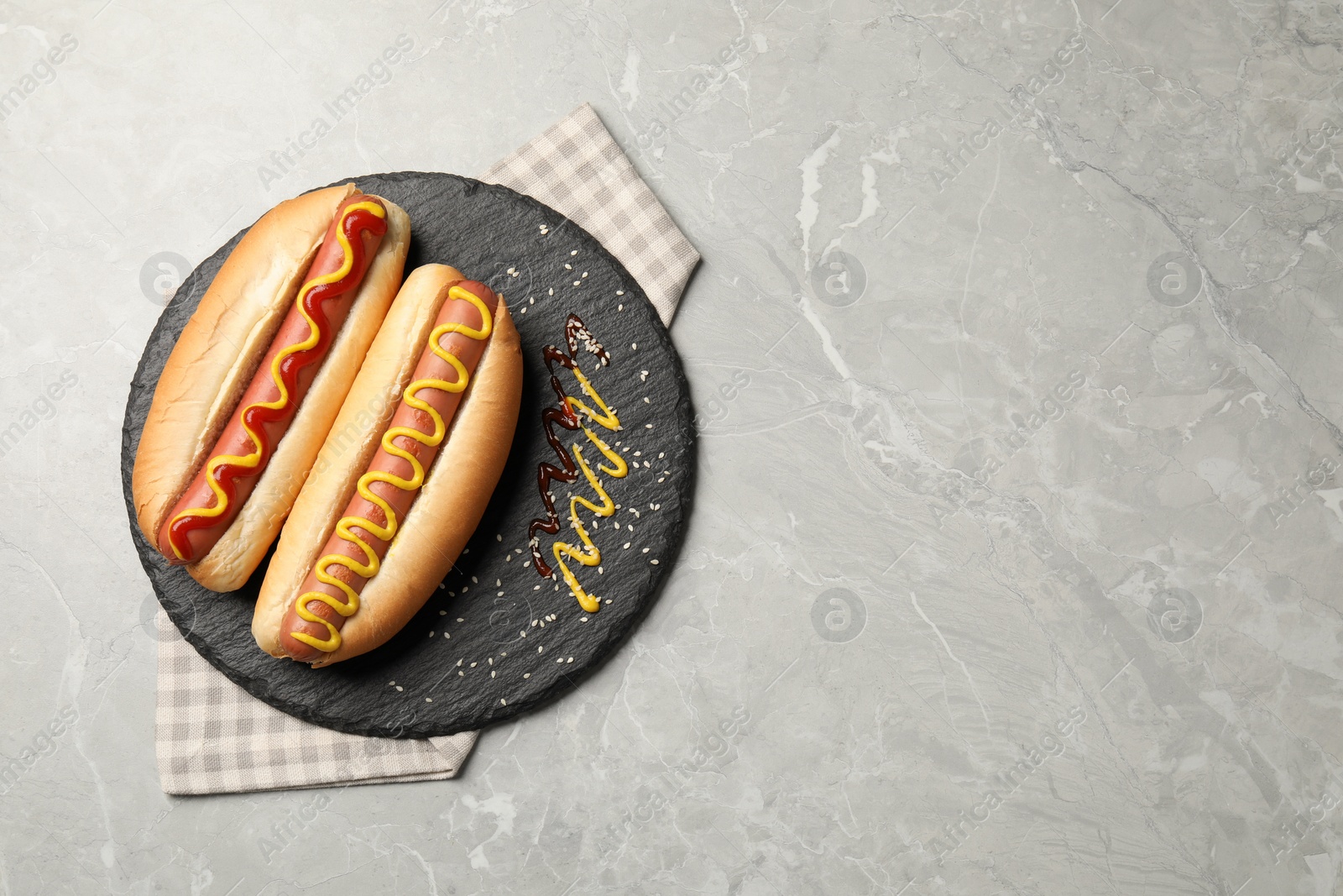 Photo of Delicious hot dogs with mustard and ketchup on light grey table, top view. Space for text