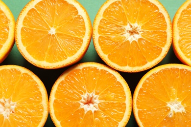 Halves of ripe oranges as background, top view