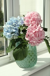 Bouquet with beautiful hortensia flowers on window sill