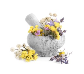 Marble mortar with different flowers and pestle on white background