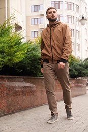Photo of Handsome man wearing stylish clothes on city street. Autumn walk