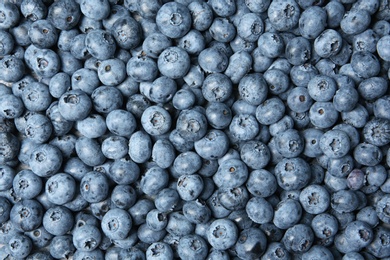 Freshly picked juicy blueberries as background, top view