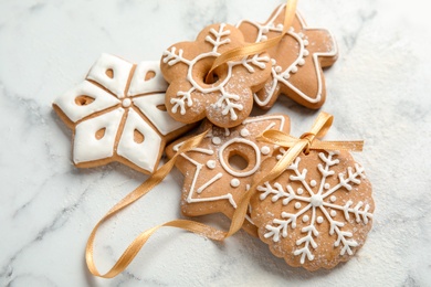 Photo of Tasty decorated Christmas cookies with ribbon on table
