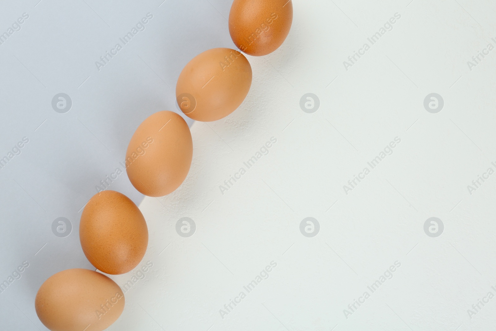 Photo of Raw chicken eggs on color background, flat lay. Space for text