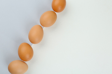 Photo of Raw chicken eggs on color background, flat lay. Space for text