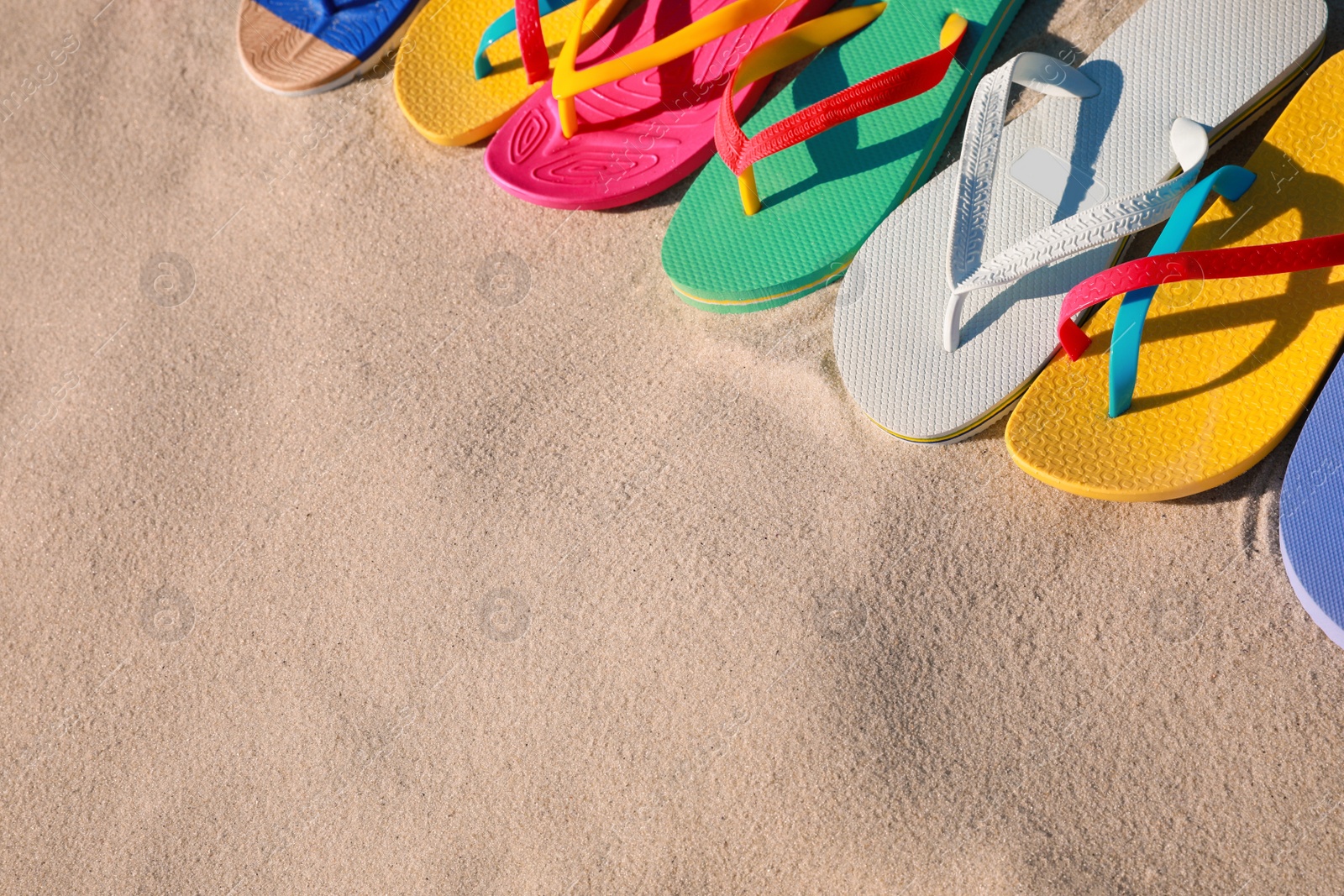 Photo of Stylish flip flops on beach, above view. Space for text