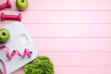 Flat lay composition with bathroom scale and measuring tape on pink wooden floor , space for text. Weight loss concept