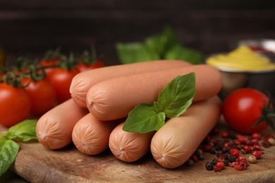 Photo of Delicious boiled sausages, tomatoes, basil and peppercorns on table, closeup