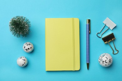Photo of Yellow planner and Christmas decor on light blue background, flat lay