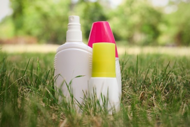 Bottles of insect repellent on green grass