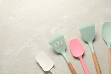 Photo of Different spatulas on light marble table, flat lay. Space for text