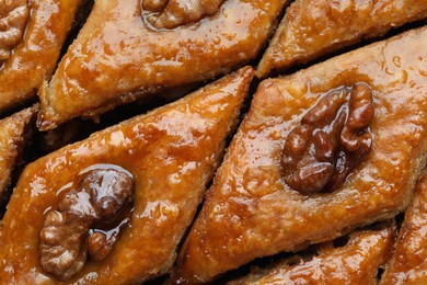 Delicious honey baklava with walnuts as background, top view