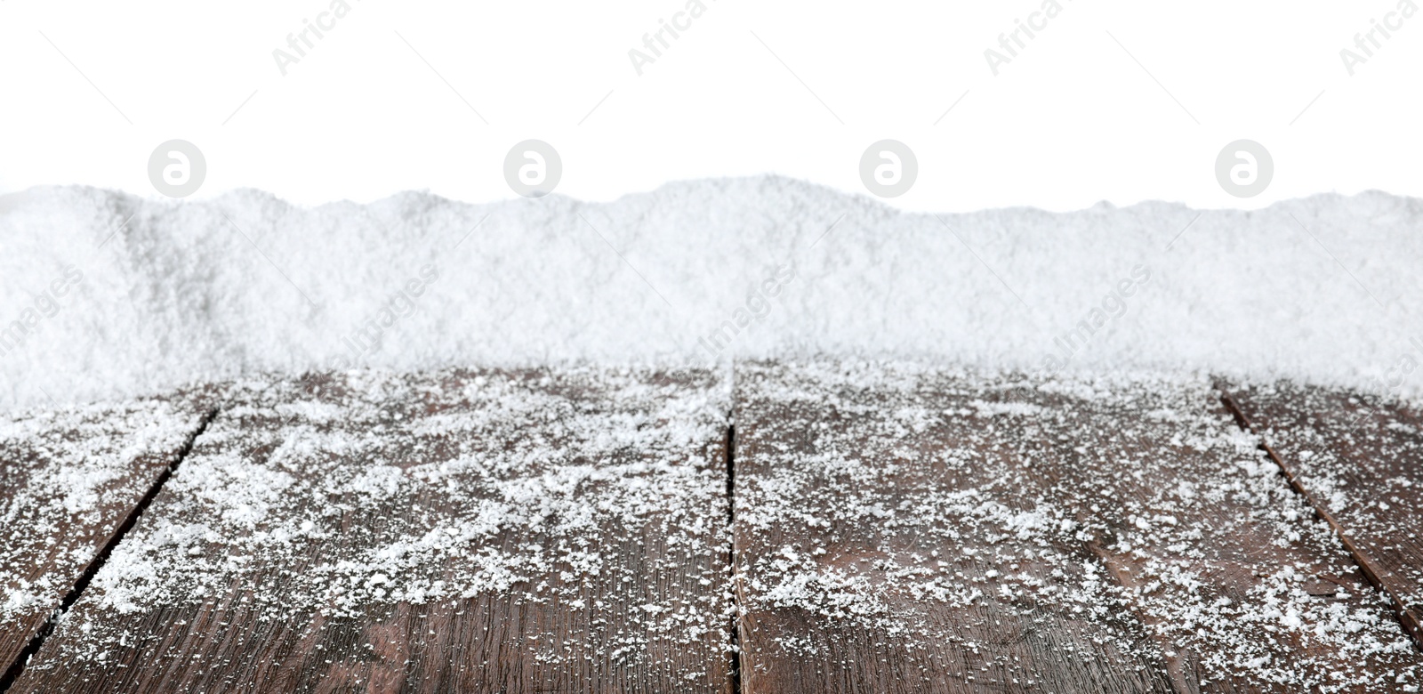 Photo of Heap of snow on wooden surface against white background