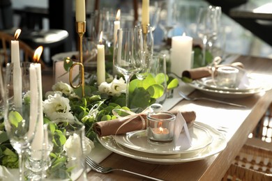 Photo of Elegant table setting with beautiful floral decor and burning candle