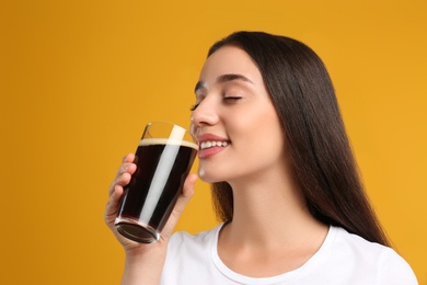 Beautiful woman with cold kvass on yellow background. Traditional Russian summer drink