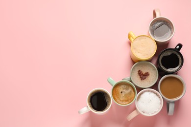 Photo of Many different cups with aromatic coffee on pink table, flat lay. Space for text